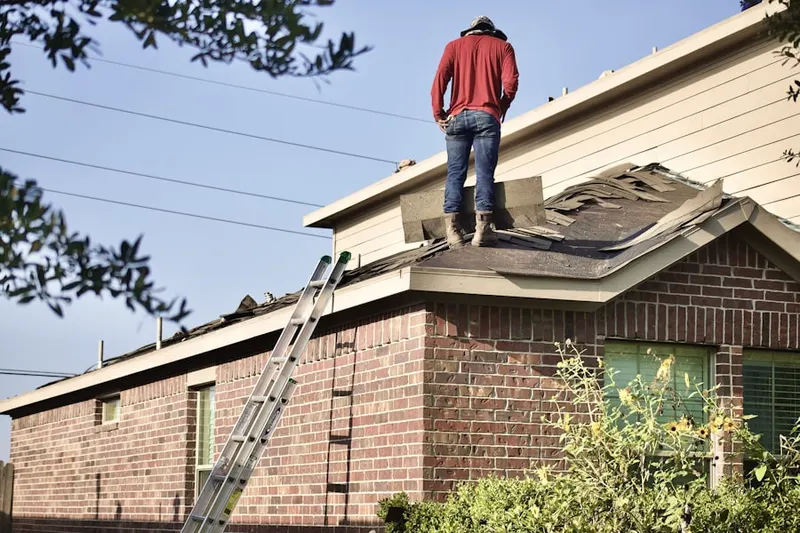 Professional roofer working on a residential roof in Riversville